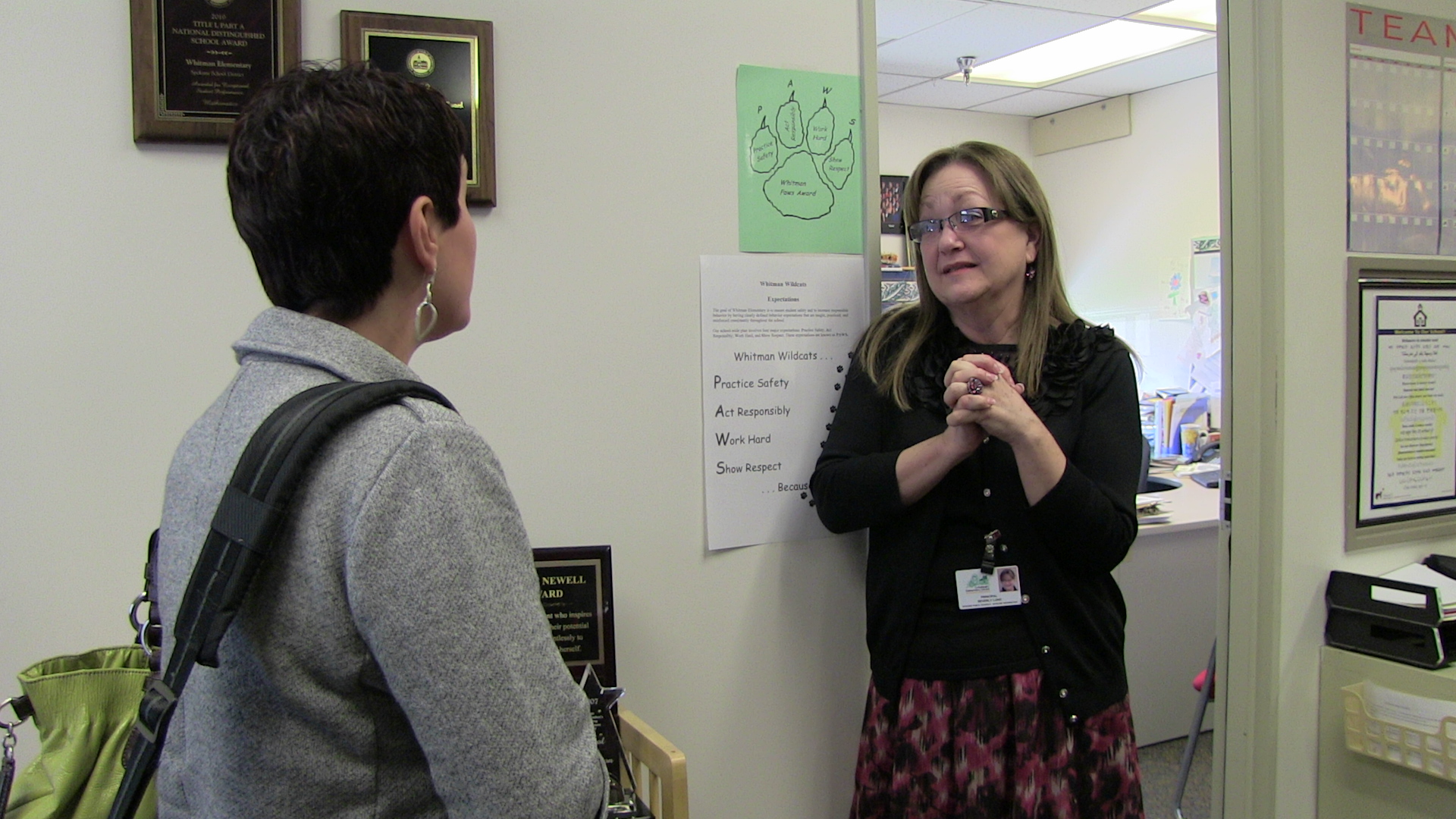 Beverly Lund, principal of Whitman Elementary School talks with Natalie Turner (back to camera).